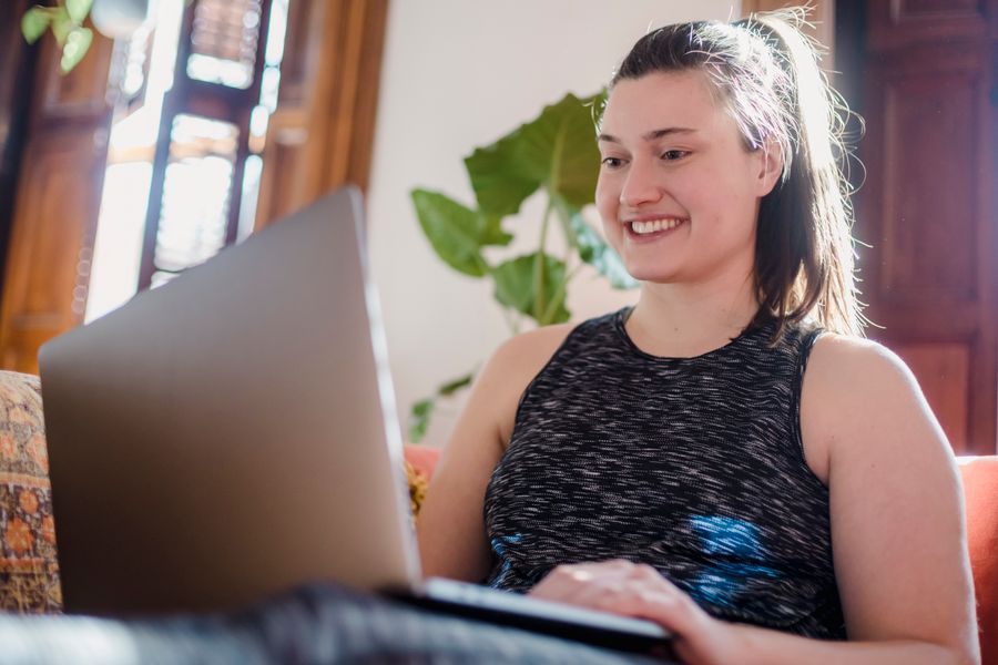 A woman smiling while using her phone